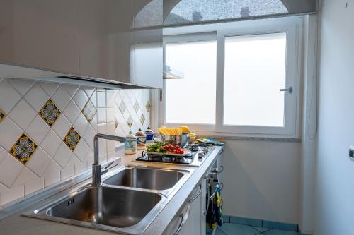 马奥莱Maiori Apartment by Marcel的厨房设有水槽和窗户。