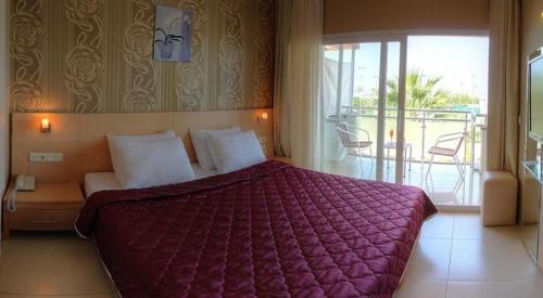 图尔古特雷斯Marin-A Hotel & Spa Turgutreis的一间带大床的卧室和一个阳台