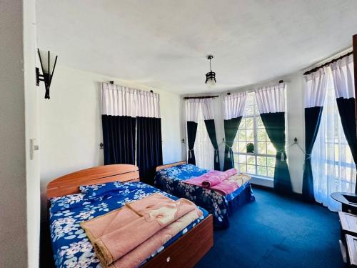 努沃勒埃利耶Lakeside Cottage by Clover的一间卧室设有两张床和窗户。