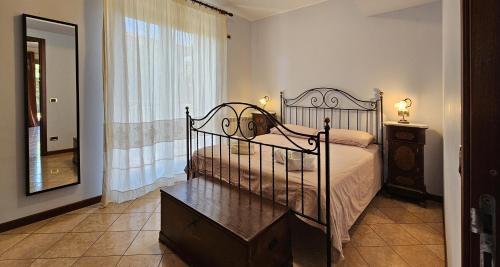 马斯卡利Etna, mare e verde (double room in villa)的一间卧室配有一张带梳妆台和镜子的床
