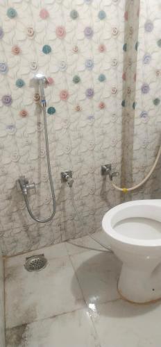 乌贾因Hotel Parvati Stey Home Ujjain的一间带卫生间和淋浴帘的浴室