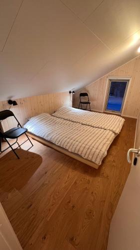 萨伦Perfect winterhouse in Sälen的铺有木地板的客房内一张大床