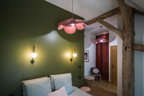 Méry-sur-CherCharmantes Maisons avec spas privatifs au calme Idéal weekend à 2 en famille ou entres amis的一间卧室设有绿色墙壁和三盏灯