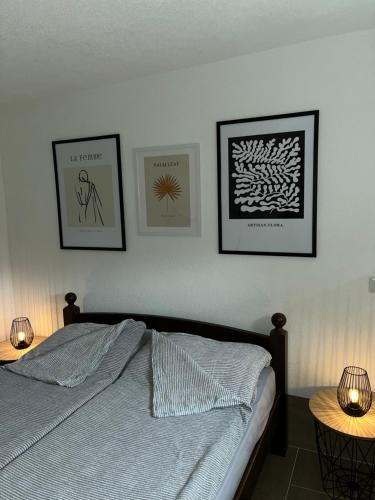 库伦瓦库夫Apartman Azra的卧室配有一张床,墙上有三幅照片