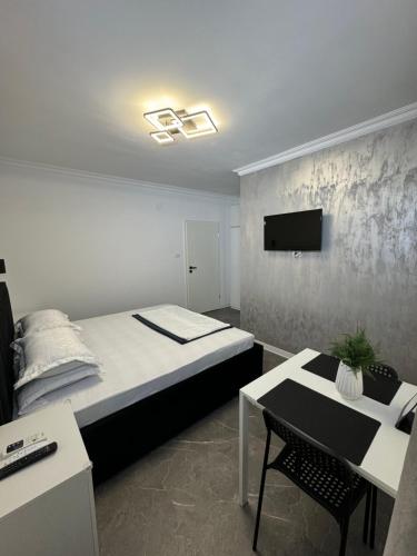 南埃福列Casa Ștefan的一间卧室配有一张床、一张桌子和一台电视。