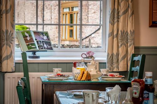 布雷肯Ty Newydd B&B的餐桌,餐桌上放着盘子和窗户