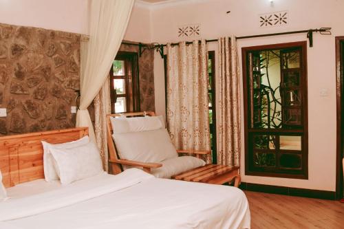卡拉图Ngorongoro Camp and Lodge的卧室配有床、椅子和窗户。