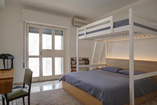 卡塔尼亚Top Floor Aparthotel Bentivoglio的一间卧室配有双层床和书桌