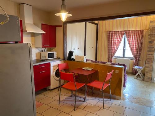 Neuvy-sur-LoireLocations de la centrale de Belleville的厨房配有红色橱柜和桌椅