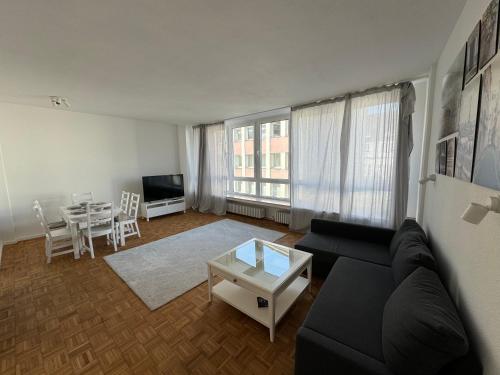 杜伊斯堡Ruhrgebiet-Apartments in Duisburg Stadtmitte的客厅配有黑色沙发和桌子