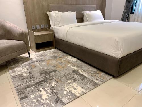 MaiduguriPolo Grand Hotel的一间卧室配有一张大床和一张沙发