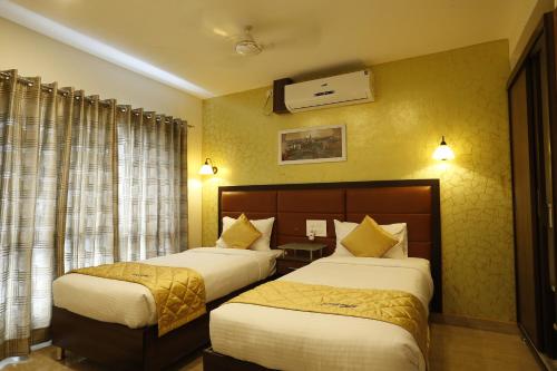 德瓦纳哈利-班加罗尔微风套房酒店的酒店客房设有两张床和窗户。