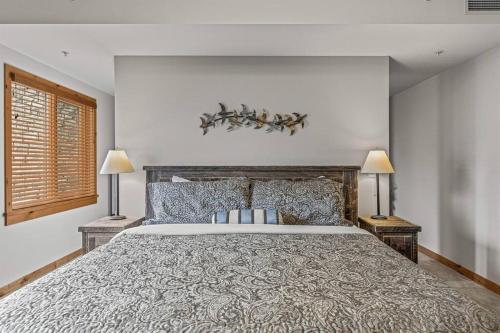 坎莫尔Spring Creek Spacious Luxury & Views at White Spruce Lodge的一间卧室配有一张大床和两盏灯。