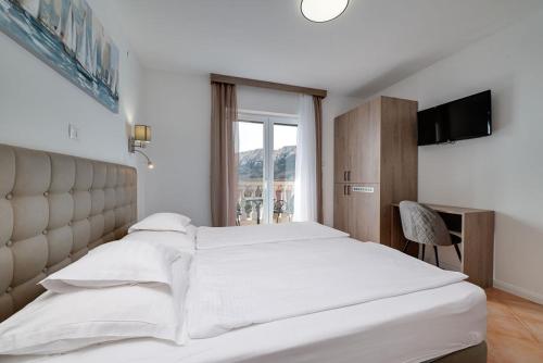 巴斯卡Bed & Breakfast Došen II的卧室设有一张白色大床和一扇窗户。