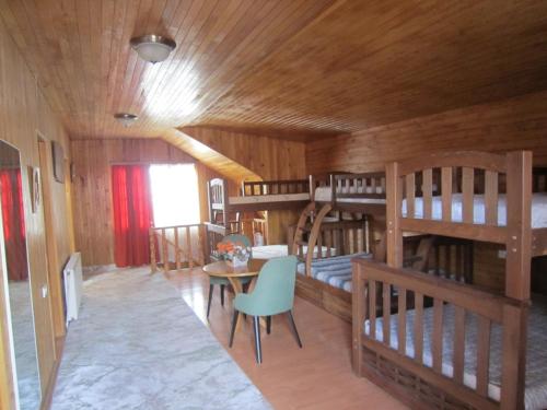 第比利斯Villa in Tbilisi的客房设有四张双层床和一张桌子及椅子。