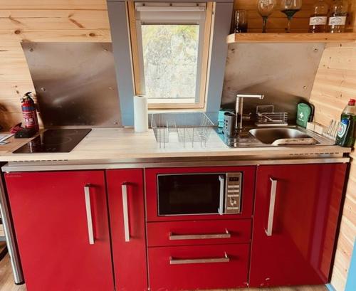 托伯莫里Hidden Hut - Aros View - Tobermory的一间带红色橱柜和微波炉的厨房