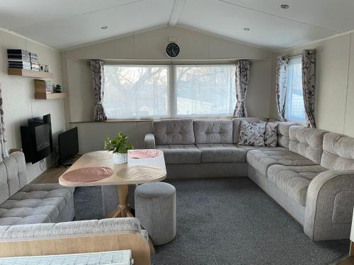 浦耳Luna-Rockley Park Poole的客厅配有沙发和桌子