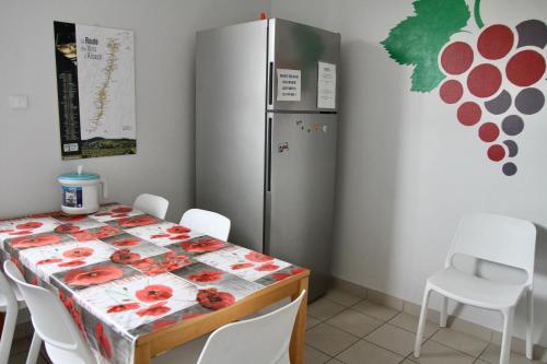 科尔马AUBERGE DE JEUNESSE的一间带桌子和冰箱的用餐室