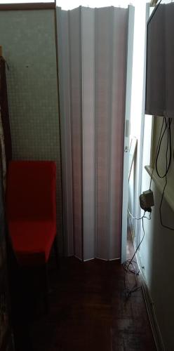 尼泰罗伊Tita's House的一间设有红色椅子和窗帘的房间