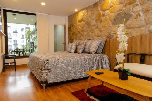 马尼萨莱斯雷吉娜马尼萨莱斯酒店的一间卧室设有一张床和石墙