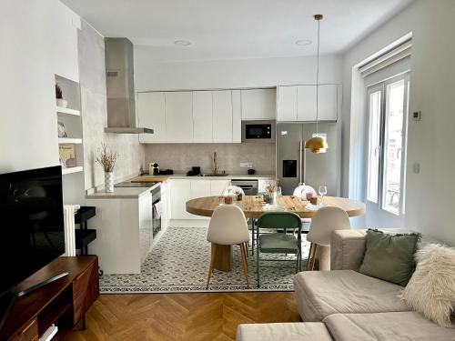 阿尔巴塞特Apartamento Marqués de Villores centro的厨房以及带桌子和沙发的客厅。