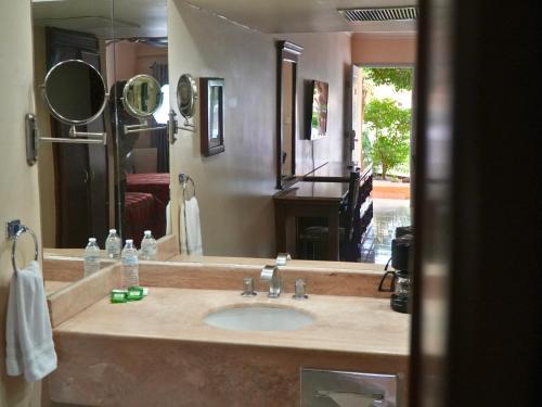 埃莫西约圣天使酒店的一间带水槽、镜子和钢琴的浴室