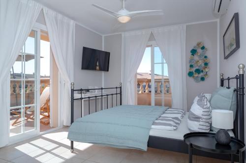 马略卡岛帕尔马Villa Palmera的一间卧室配有一张带吊扇的床