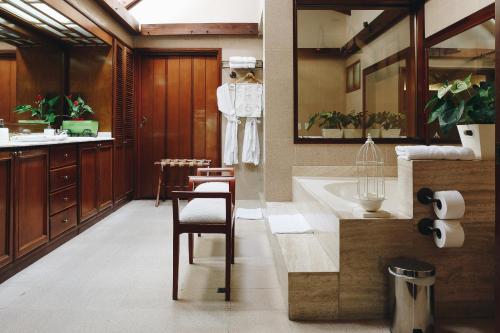 佩雷拉Sazagua Hotel Boutique的一间带水槽、浴缸和椅子的浴室