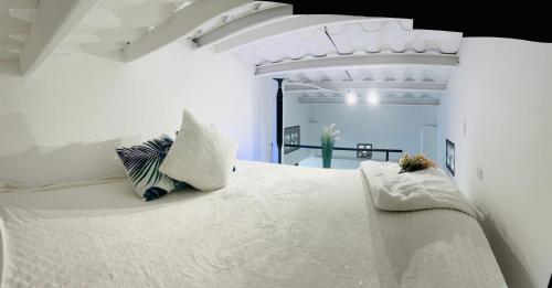 SoráApartment with loft in Altos del Maria的白色卧室配有一张带枕头的大白色床