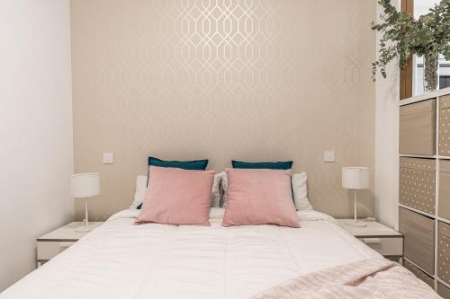 马德里BNBHolder Hunky ATOCHA的卧室配有带粉红色枕头的大型白色床