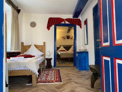 穆里吉奥尔Casa Soarelui的一间卧室配有一张床和一个蓝色的门
