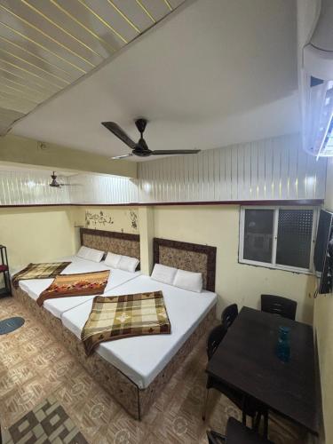乌贾因sun guest house的一间卧室设有两张床、一张桌子和天花板