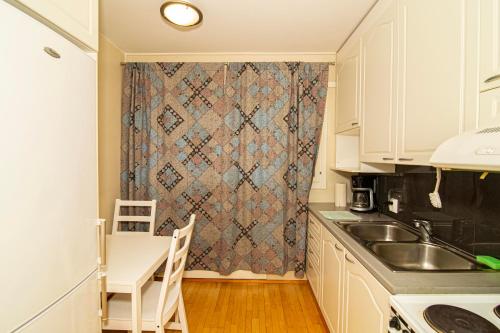 图尔库2-Bedroom Apartment in Heart of City Center的厨房配有水槽、桌子和窗帘