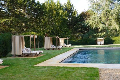 ReugnyRelais & Château Louise de La Vallière的后院设有带椅子的游泳池和帐篷