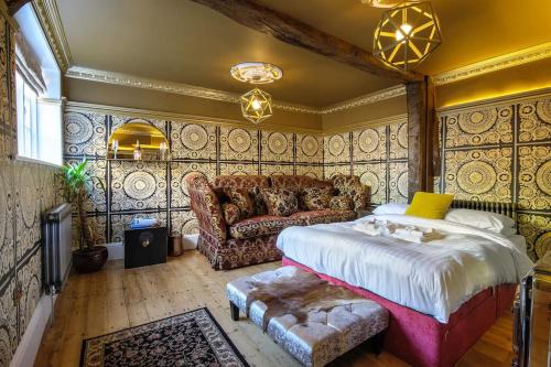 萨弗伦沃尔登Luxury 3 Bed Manor House Hot Tub & Cinema的一间卧室配有一张床和一张沙发