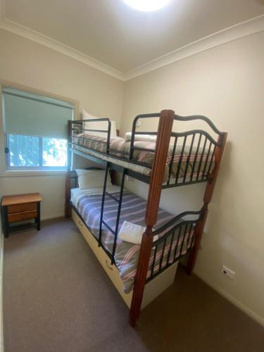 TemoraAirfield Tourist Park Temora的带窗户的客房内的两张双层床