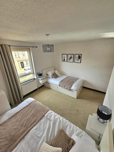 剑桥Lovely, spacious home near Cambridge City Centre的一间卧室设有两张床和窗户。
