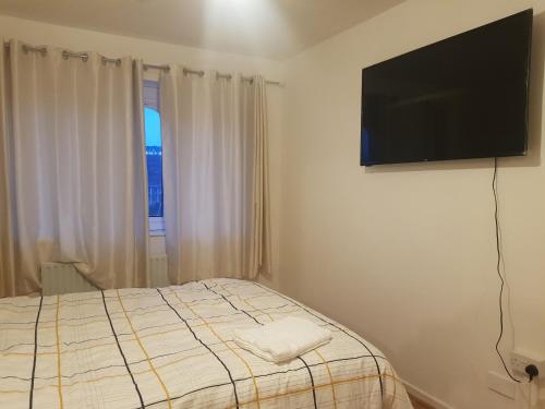 伯明翰3BED Maisonette Near CityCentre的一间卧室配有一张床和一台平面电视