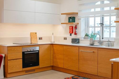 斯利马Lovely 3 bed - Apartment -Sliema的厨房配有木制橱柜和黑烤箱。