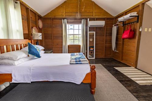 Bon AccordBeach Studio in Crown Point的卧室配有一张床铺,位于带木墙的房间内