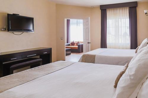 特基斯基亚潘圣何塞雷亚尔酒店的酒店客房设有两张床和一台平面电视。