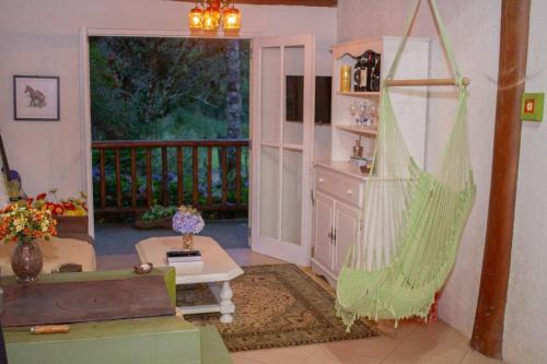 AnnitapolisCasa de Campo - Alameda dos Pinus的一间带吊床的客厅和一个阳台