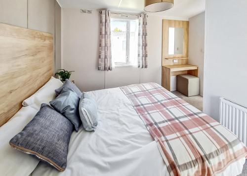 梅布尔索普Towervans Caravan Park的卧室配有带蓝色枕头的大型白色床