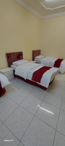 麦加ديار الحجاز 1的白色和红色的客房内的三张床