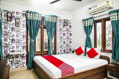加尔各答OYO Flagship Shraddha Residency 2的一间卧室配有红色枕头的床