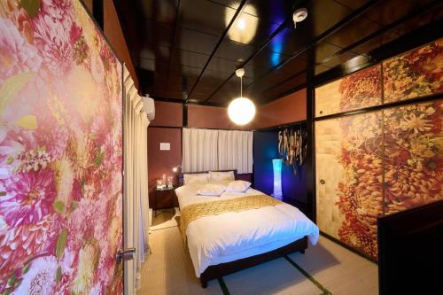 别府花の宿　別府・鉄輪的一间卧室设有一张床和鲜花墙