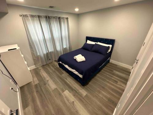 帕特森The Comfy Suite - 1BR with Free Parking的一间卧室配有一张带蓝色床单的床和一扇窗户。