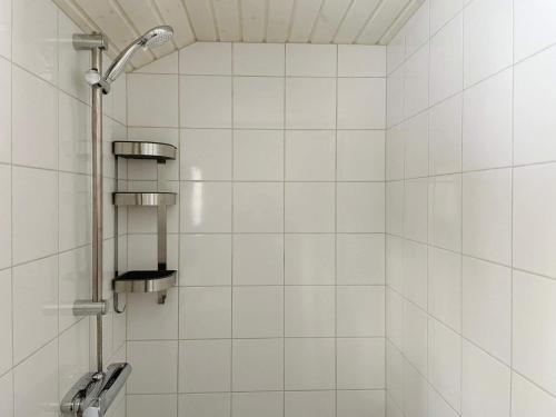 诺尔泰利耶Holiday home NORRTÄLJE VI的白色瓷砖淋浴和淋浴头