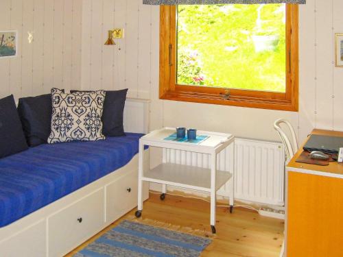 MalmköpingHoliday home MALMKÖPING II的一间配有沙发、桌子和窗户的客房