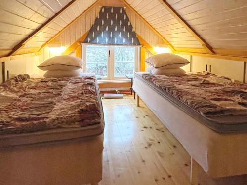 龙讷比Holiday home Ronneby XIII的两张床位于带窗户的房间内